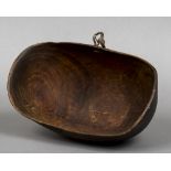 A Kenyan wooden bleeding bowl Of deep oval form with attached leather strap. 36 cm wide.