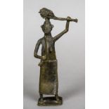 A Benin bronze figure of a woman Modelled wearing a skirt, holding a sword and a club. 22 cm high.