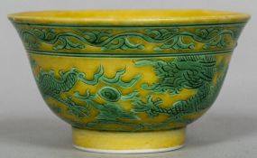 A Chinese porcelain bowl Decorated with green painted dragons chasing flaming pearls on a yellow