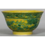 A Chinese porcelain bowl Decorated with green painted dragons chasing flaming pearls on a yellow