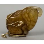 A 9 ct gold mounted carved russet jade pendant Worked as an exotic fruit. 6.5 cm long overall.