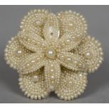 A Victorian seed pearl mounted mother-of-pearl brooch Formed as a flowerhead. 4 cm wide.