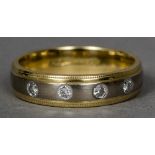 An 18 ct two-tone gold and diamond ring Of band form set with four gypsy set diamonds.