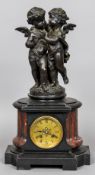 A 19th century patinated bronze mounted mantel clock The case surmounted with twin cherubs,