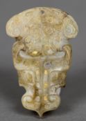 A Chinese Han dynasty gold inlaid and carved jade pendant Worked as a stylised dragon mask.