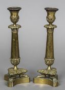 A pair of 19th century bronze candlesticks Each with beaded drip-pans above the knop and acanthus