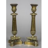 A pair of 19th century bronze candlesticks Each with beaded drip-pans above the knop and acanthus