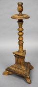 An 18th/19th century Continental pine candle stand The turned column standing on a triangular