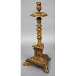 An 18th/19th century Continental pine candle stand The turned column standing on a triangular