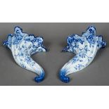 A pair of faience blue and white wall pockets Each of folded cornucopia form decorated with floral