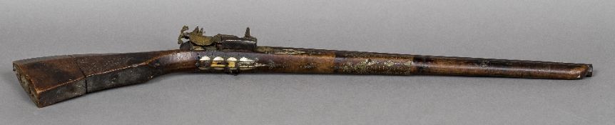 An antique North African mother-of-pearl and metal inlaid flintlock rifle 95 cm long.