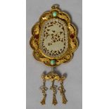 A gilt white metal jade and gem set mounted filigree pendant The jade panel carved and pierced with