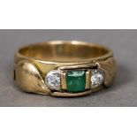 An unmarked 18 ct gold diamond and emerald set ring Of band form with twin leaf decorations.