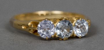 An unmarked 9 ct gold three stone diamond ring Each claw set stone spreading to approximately 0.