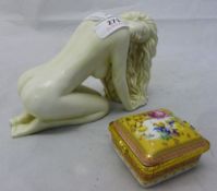 A nude figure of a woman and decorative pill box