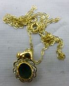 A diamond and emerald pendant with a gold chain
