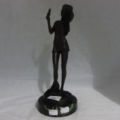 A bronze figure in the form of a girl styling her hair