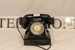 A bakelite telephone and a telephone sign