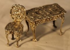 A miniature silver table and chair