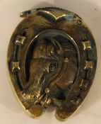 A brass vesta in the form of a horse shoe with horse's head