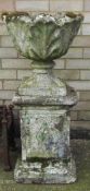 A composite stone garden pedestal urn