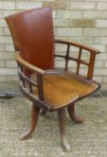 An Arts and Crafts oak swivel desk chair