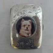 A silver cigarette case depicting a dog