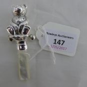 A silver teddy bear rattle