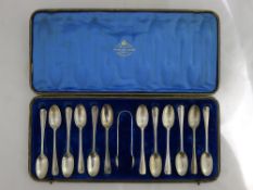 A cased set of twelve silver spoons and a pair of tongs