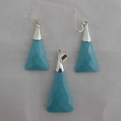 A silver and turquoise earrings and pendant set