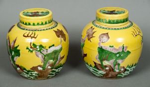 A pair of Chinese yellow ground ginger jars Each decorated in the round with mythical beasts.