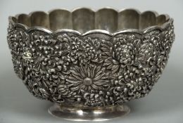 A large repousse decorated silver bowl, possibly Japanese Of lobed form with gilt interior,