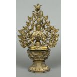 A Chinese gilt bronze figure of a multi-armed deity Modelled seated before a pierced arch,