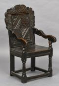 An 18th century oak Wainscot chair The scroll carved top rail above a band of geometric inlays over