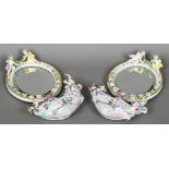 A pair of Continental porcelain mirrors together with a pair of associated Continental porcelain