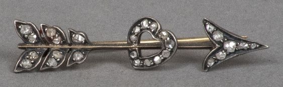 A Victorian diamond set white and yellow metal sweetheart brooch Formed as an arrow piercing a