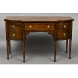 A 19th century mahogany breakfront sideboard The shaped top above three frieze drawers with ring