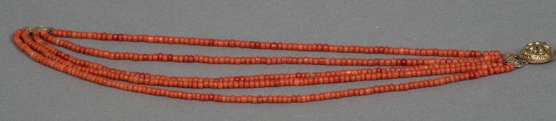 A five strand coral bead necklace Set with a pierced gold clasp. Approximately 40 cm long.