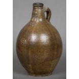 A 17th century stoneware Bellarmine mask flagon The bulbous body with moulded prunt and loop handle.