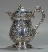 An Edwardian Irish silver embossed lidded jug, hallmarked Dublin 1907,