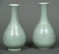 A pair of Chinese celadon ground vases Each with a lappet decorated flared neck above the main