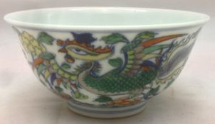 A Chinese Doucai porcelain tea bowl Decorated with a pair of phoenix amongst scrolling blossom,