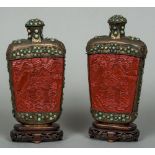 A pair of Chinese cabochon inset metal mounted cinnabar lacquered table snuff bottles Each