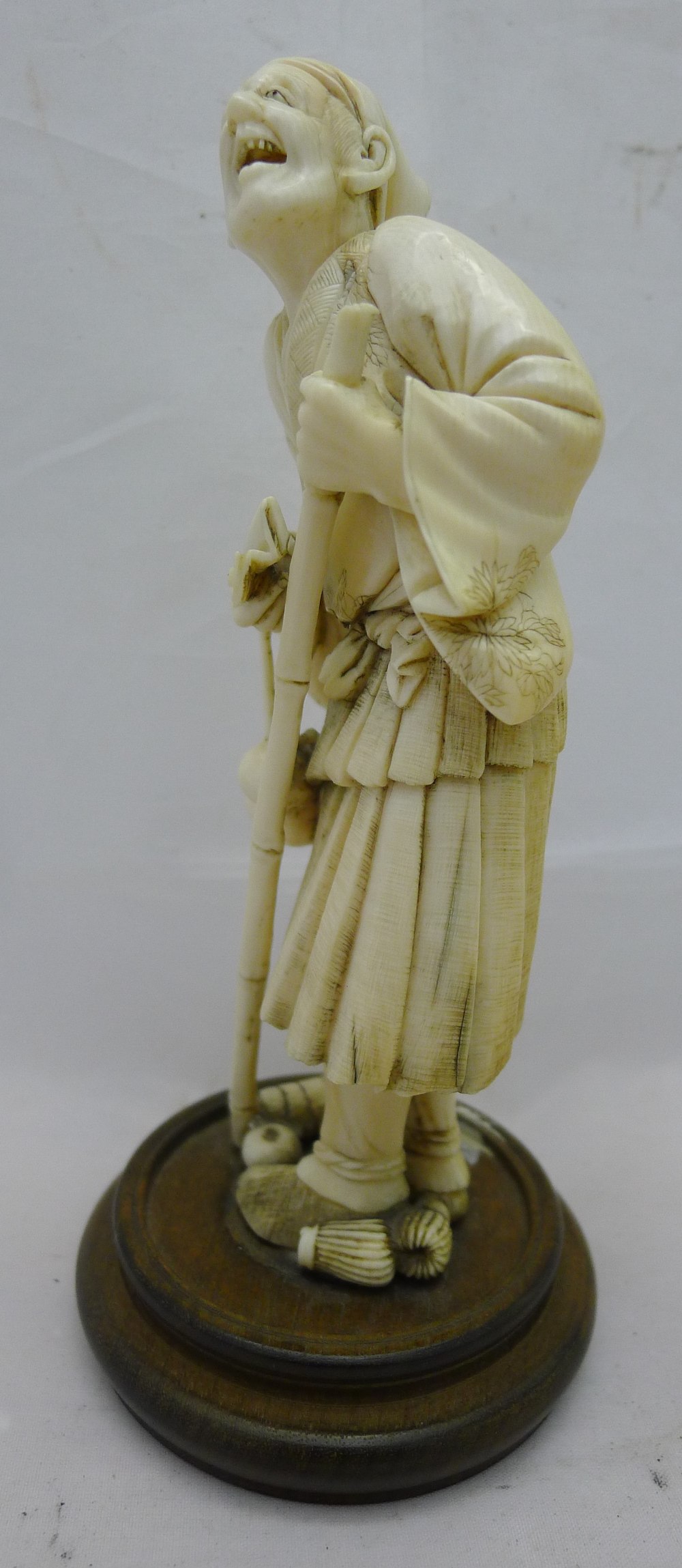 A 19th century Japanese ivory okimono Formed as a male figure holding a stick and a fan with a - Image 5 of 7