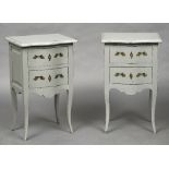 A pair of white painted bedside drawers Each with serpentine top above two drawers with brass
