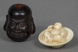 A late 19th century carved ivory netsuke Formed as a seated robed figure,