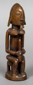 An African carved wooden tribal figure Modelled as a male figure with breasts. 24 cm high.