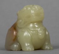 A Chinese carved celadon and russet jade temple lion Modelled seated. 3 cm high.