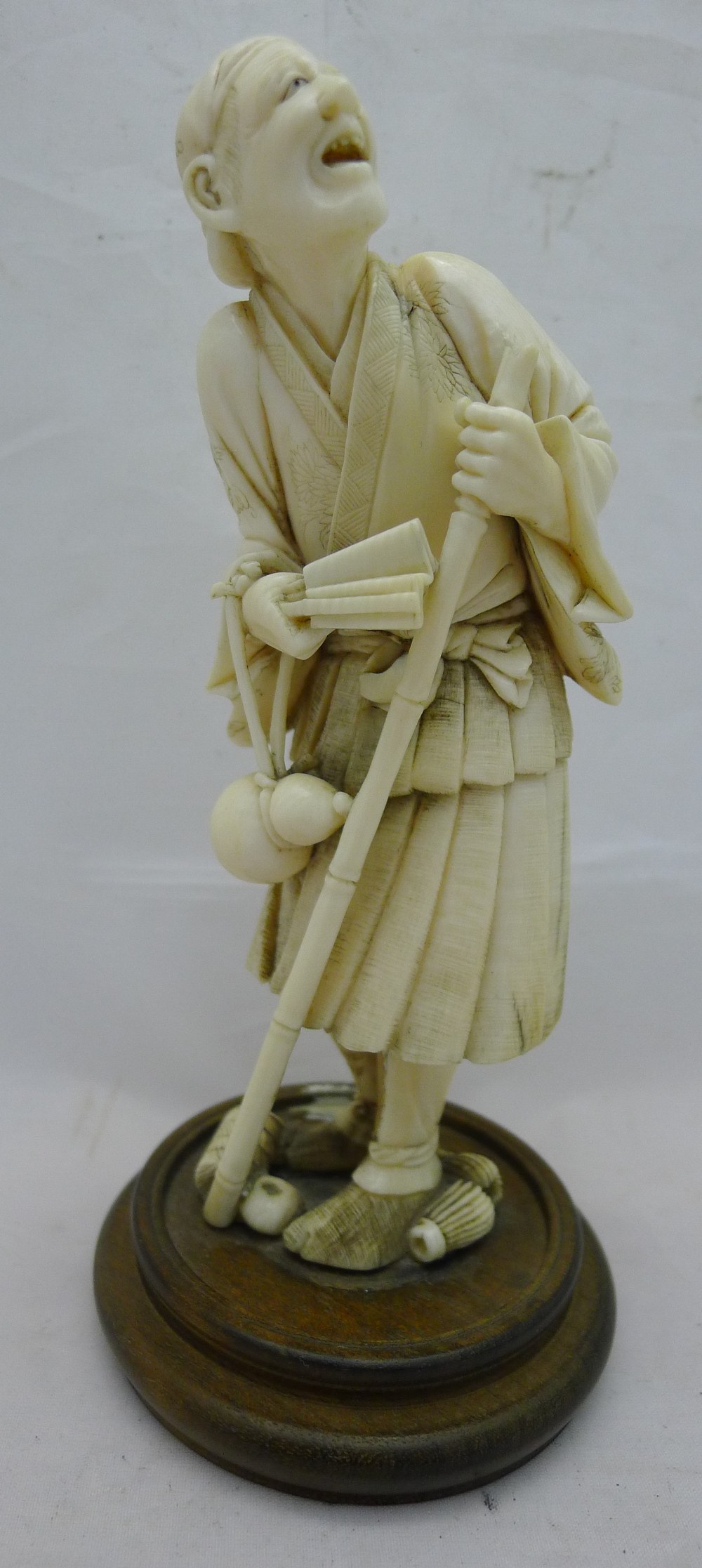 A 19th century Japanese ivory okimono Formed as a male figure holding a stick and a fan with a - Image 2 of 7