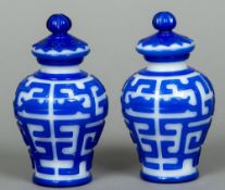 A pair of Peking overlay blue and white glass vases Each of ovoid form with removable lid.